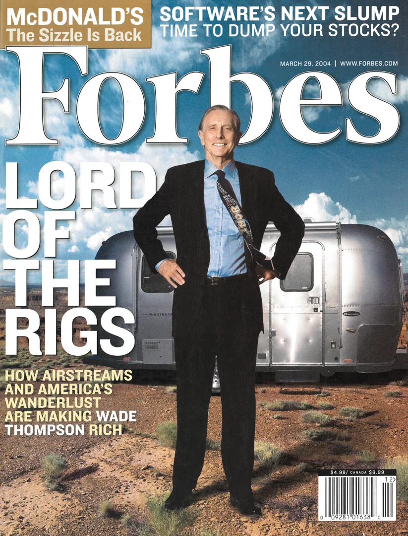 Forbes magazine cover featuring a smiling man in a suit standing in front of an Airstream trailer, with headlines about Airstreams, McDonald’s, and technology stocks. Blue sky with clouds in the background.