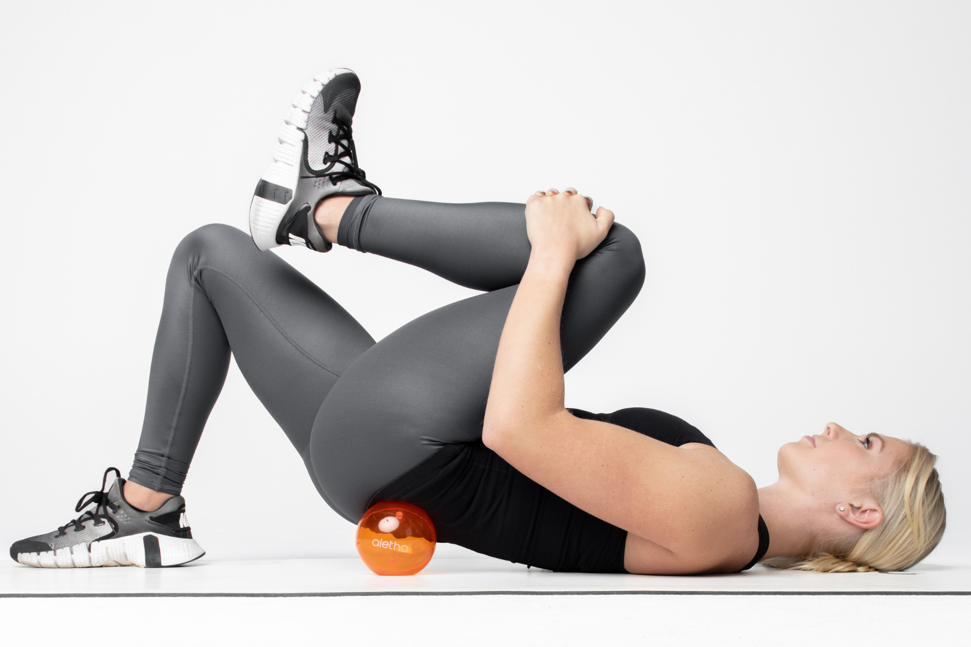 woman using ball to release tight glute