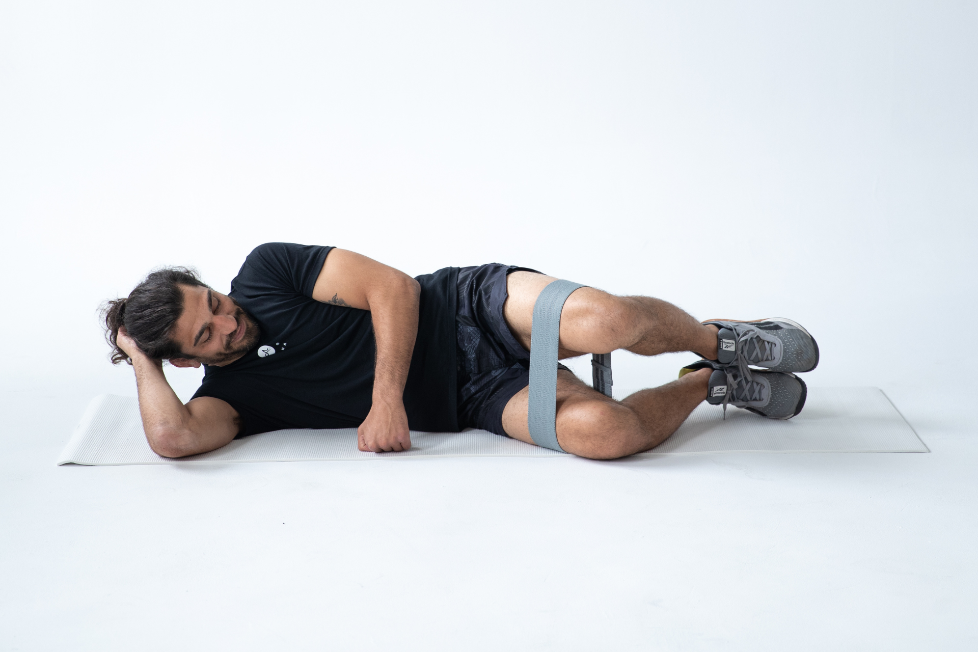 null man performing clamshell exercise with resistance band