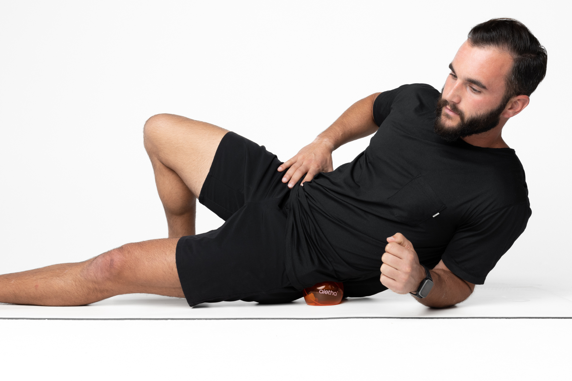 null man using massage therapy ball on outer hips