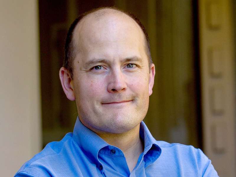 Paul Bollyky headshot in blue shirt in outdoor setting.