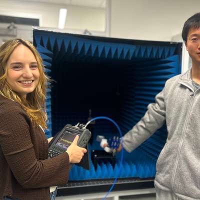 Geneva Ecola and Jida Zhang hold their thermal noise device in a lab
