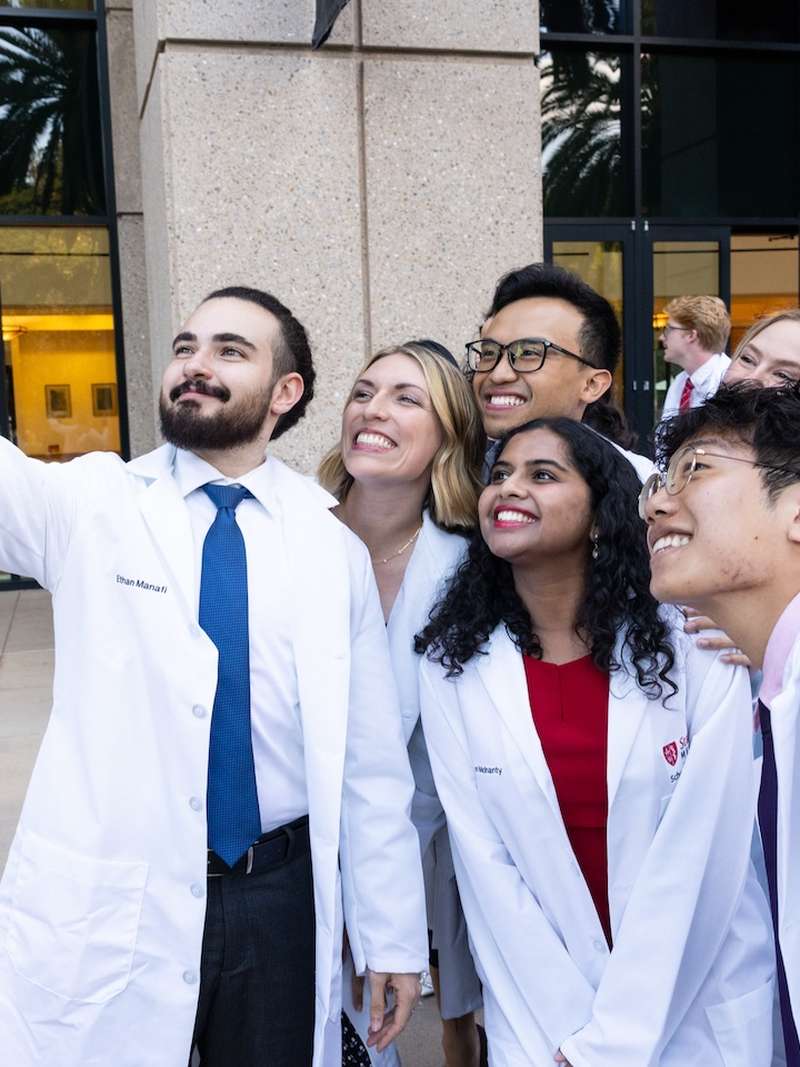 MD students take a group selfie outside after their white coat ceremony.