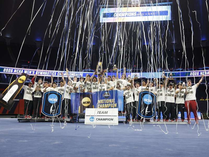 The men's gymnastics team poses for a photo while celebrating their NCAA Championship win.
