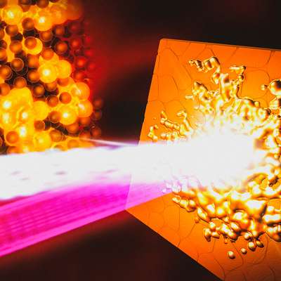 Artist's illustration of a bright laser beam striking a copper surface and melting it into glowing droplets, beside a cluster of atoms.