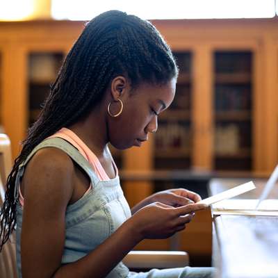 Kene Nzelu, a junior majoring in history, pores over items from the Stanford University Archives for her final project that looks at the role of women in Stanford’s history.