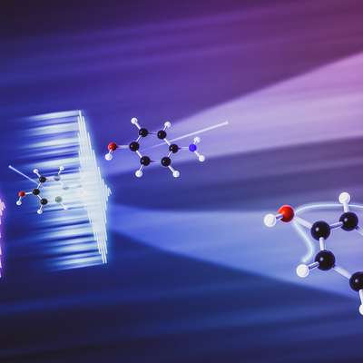 A colorful scientific illustration shows laser light interacting with molecular structures against a blue and purple background.