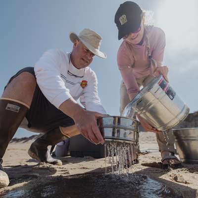 Steve Lonhart and Libby Mohn filtering sand and ocean water samples to search for microplastics in the ocean.