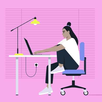 A woman works at a desk on a laptop, sitting in a chair, with a bright lamp and pink background.