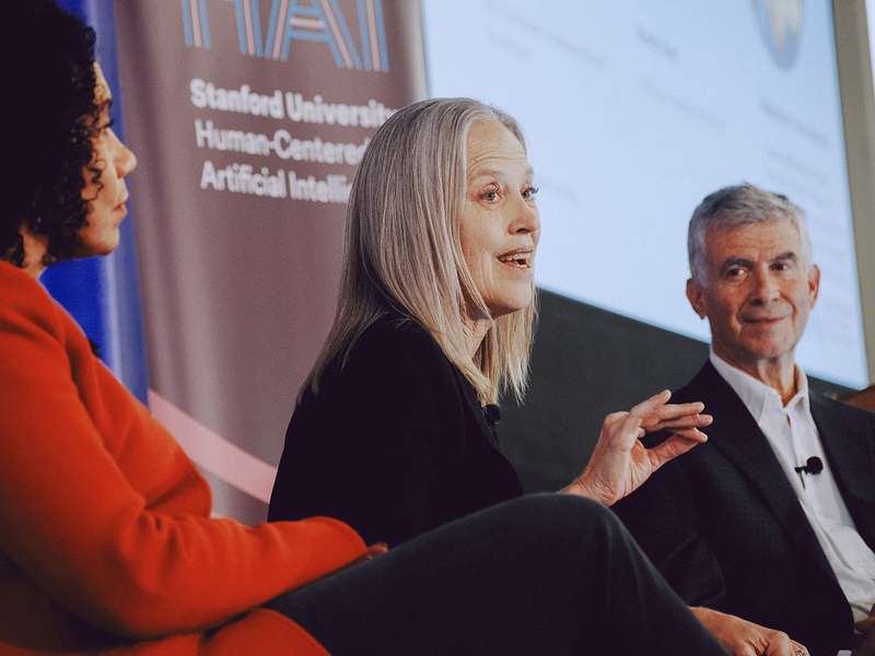 Panelists including Wendy Kopp, center, in discussion onstage, with Stanford HAI banner in background.
