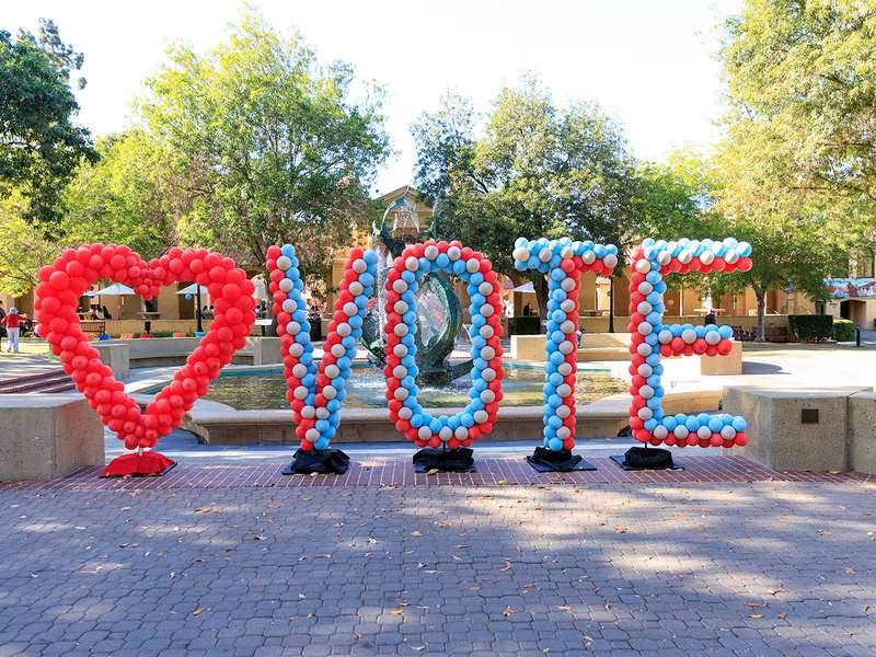 Balloons in the shape or a heart and spell out "vote" in front of Memorial Fountain on the Stanford campus.