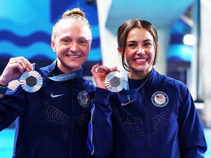 Kassidy Cook and her teammate smile as they hold up their silver medals at the Paris 2024 Olympics.