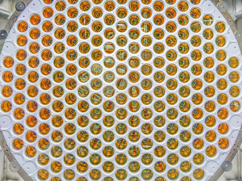 Close view of a circular array of hundreds of gold-toned light sensors packed into a white panel.