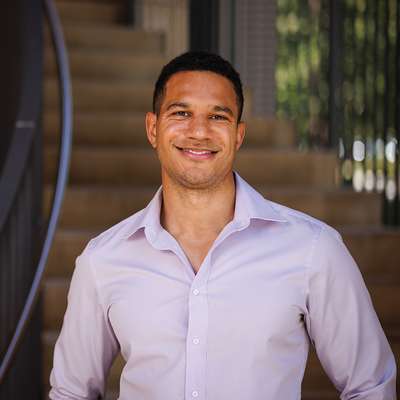 Julian Nyarko standing in front of a staircase and posing for a profile photo.