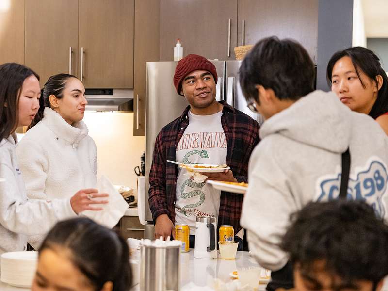 Students gather in a dorm dinning area to enjoy snacks during a Civic Salon discussion.