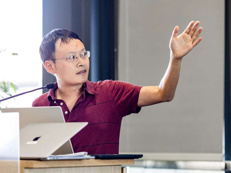 James Zou gestures toward the screen as he gives a talk at Stanford in October 2024.