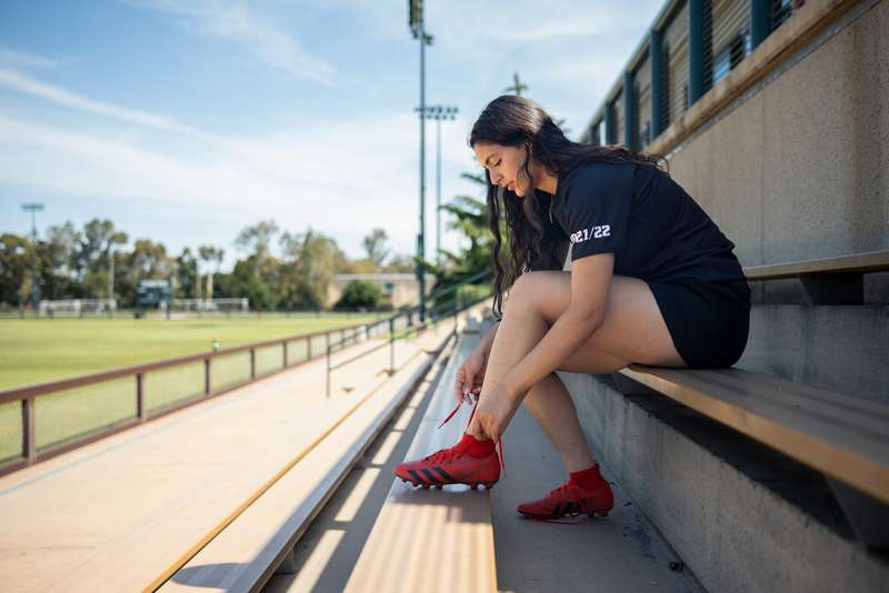 Student tying cleat shoes