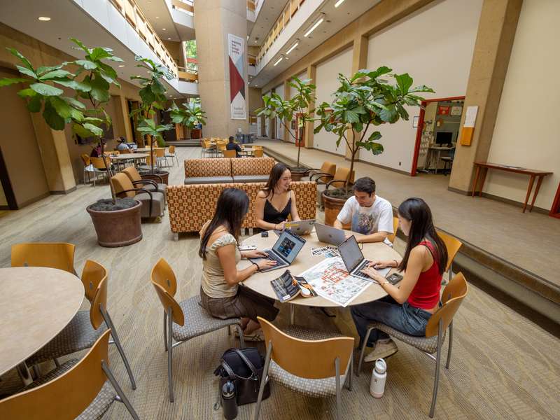 Students sitting around a desk, talking