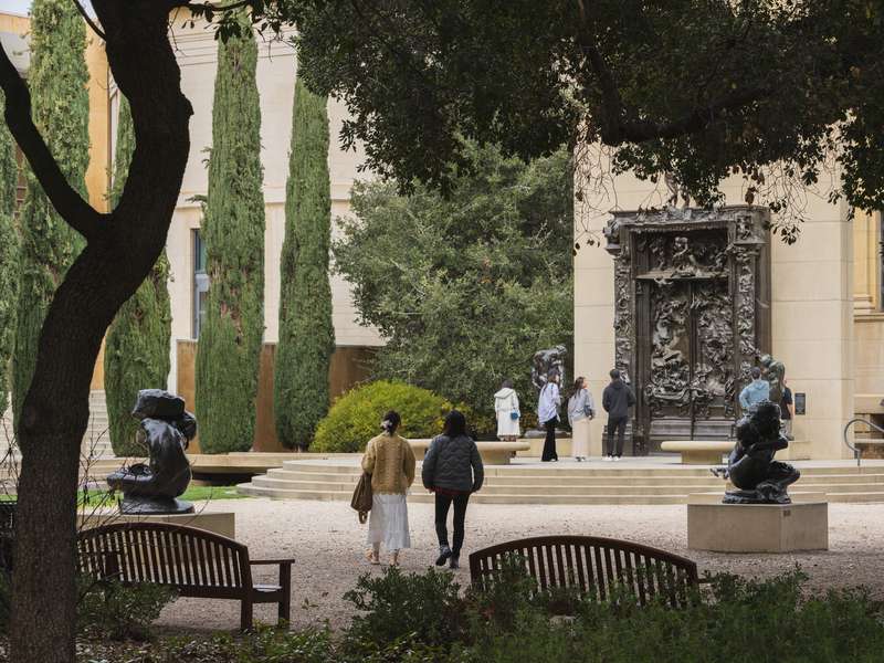 Visitors walk through the Rodin Sculpture Garden toward the bronze "Gates of Hell."