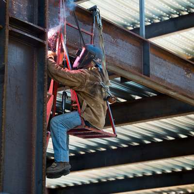 A welder works on the iron framing of the 408 Panama Mall Building.