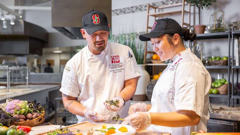 Stanford dining staff preparing fresh vegetables and herbs