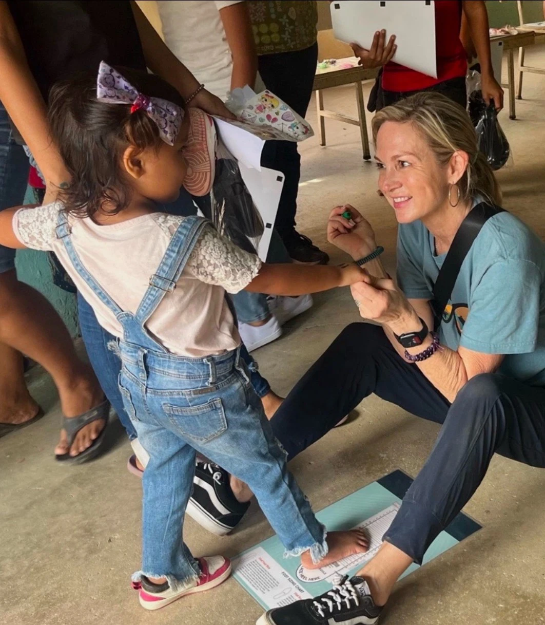Deborah Guzman doing a shoe fitting for a girl in Honduras