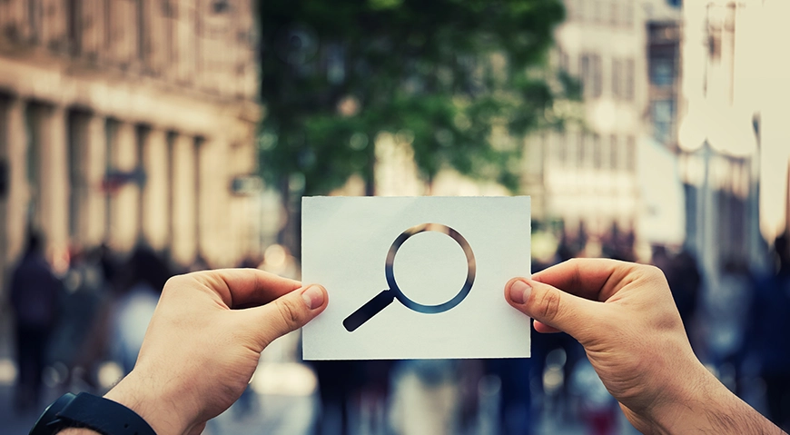 Picture of a person holding up a cutout image of a microscope