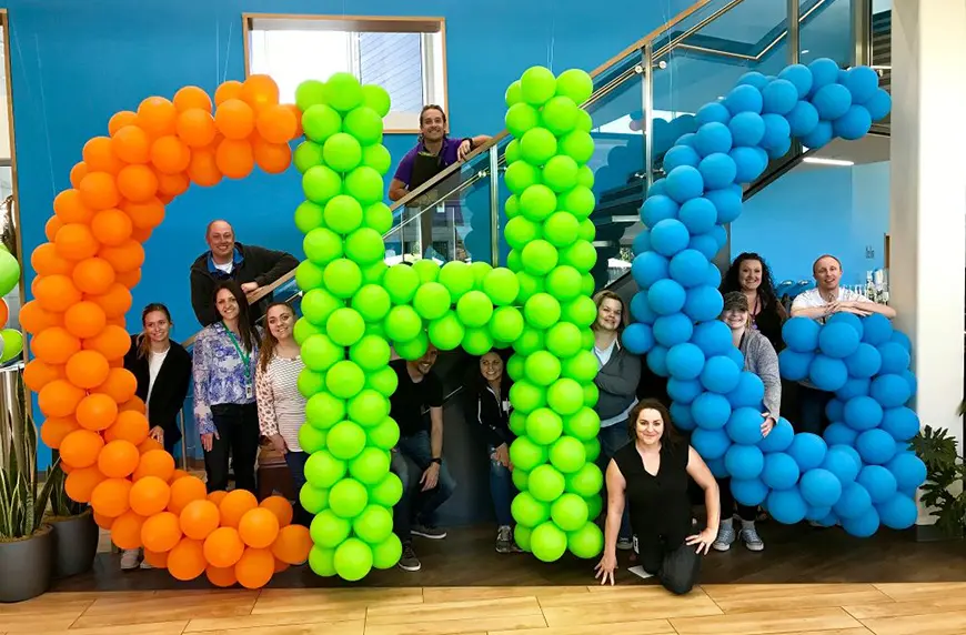 CHG employees with balloons that spell CHG