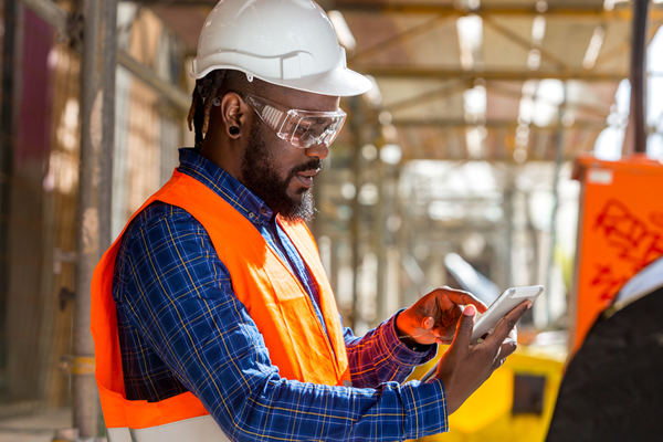 Contractor on jobsite working on a tablet
