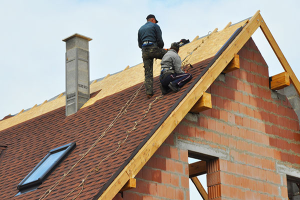 Roofers installing shingles on a steep-slope roof