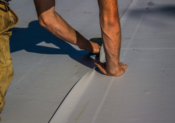 Contractor installing a TPO roofing membranes.