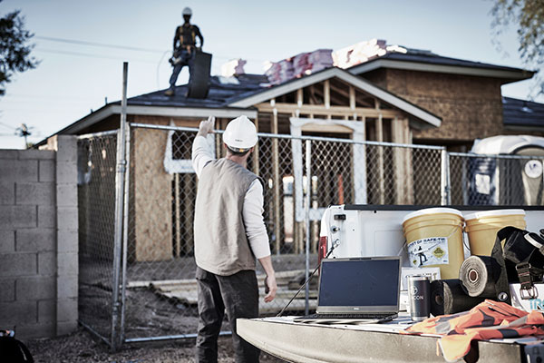 A trainer and apprentice use a saw.