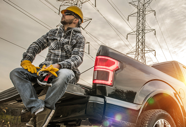 A roofer thinking about his commercial auto insurance options while sitting in his truck.