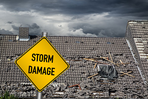 A damaged roof after a storm with a sign that says "storm damage."