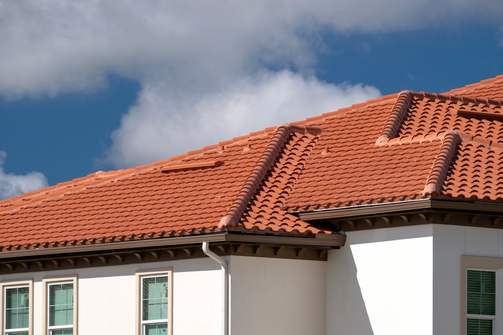 A white home with a red clay tile roof.