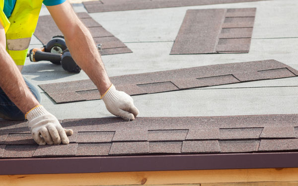 Roofer installing shingles