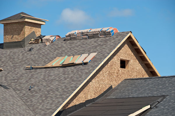 Partly installed asphalt roof on a new house.