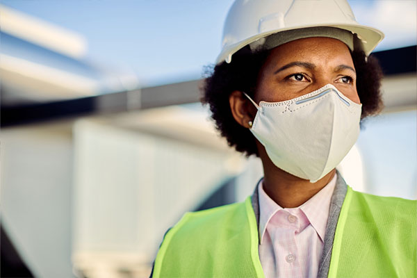 An African-American roofing contractor in hardhat and hi-vis vest
