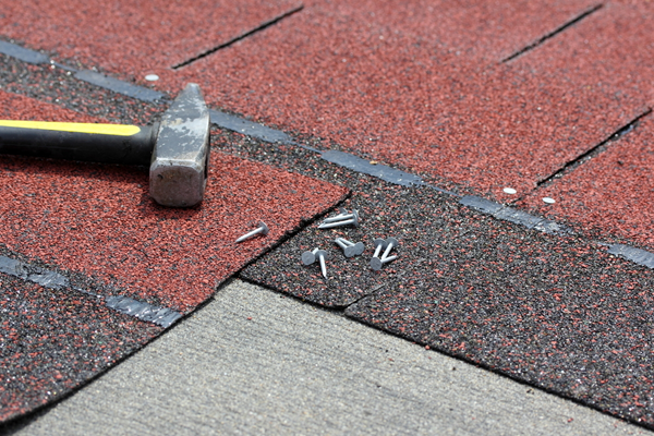 hammer and nails on top of a roof installation