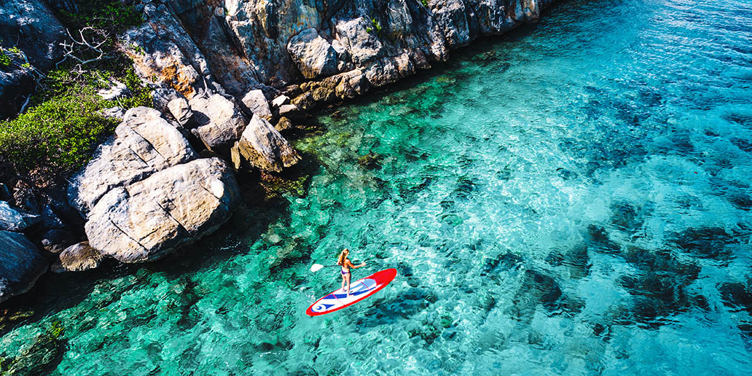 Aerial view of a woman on paddleboard in tropical water, Lovango Cay, United States Virgin Islands