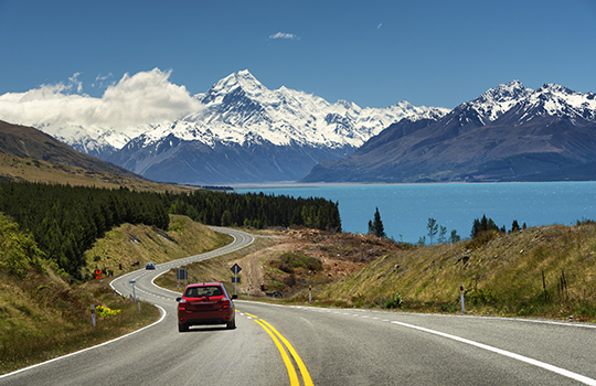 Red car on the road to Mt.Cook, New Zealand