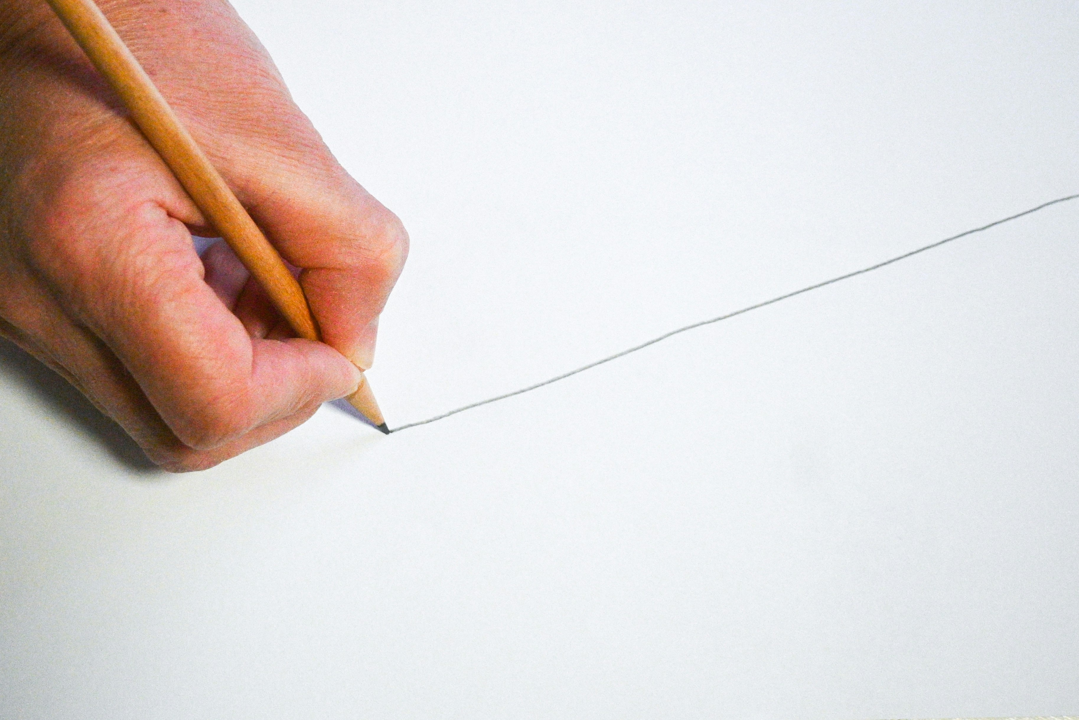 hand drawing a line with a pencil