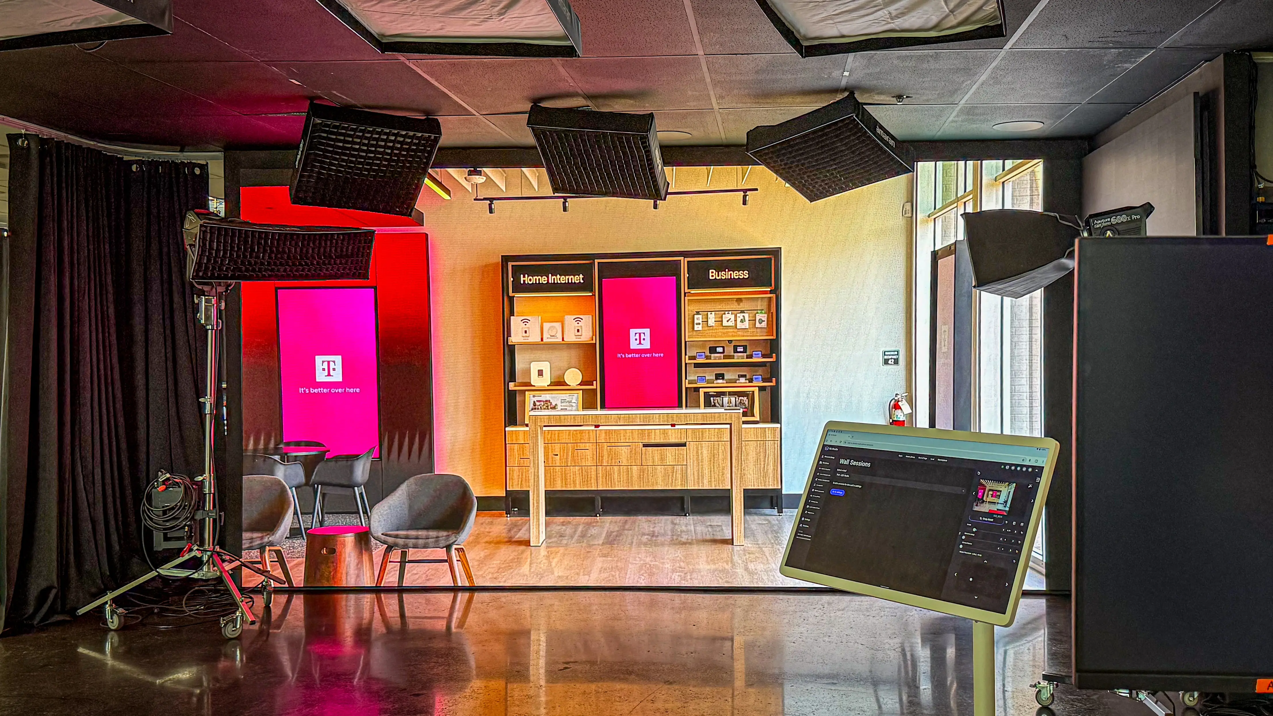 A modern, well-equipped studio with lights, two chairs, a table, digital screens displaying 