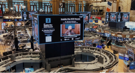 NY Stock Exchange trading floor with large digital screens displaying "Inside the ICE House" featuring a guest speaker, surrounded by trading desks.