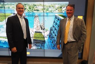 Ed de Avila and Peter Cole of Madison Marquette at ICSC RECon, in front of a rendering of The Wharf