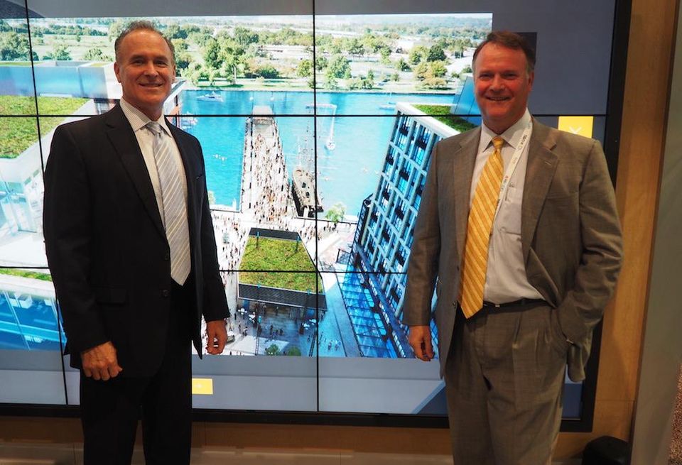 Ed de Avila and Peter Cole of Madison Marquette at ICSC RECon, in front of a rendering of The Wharf