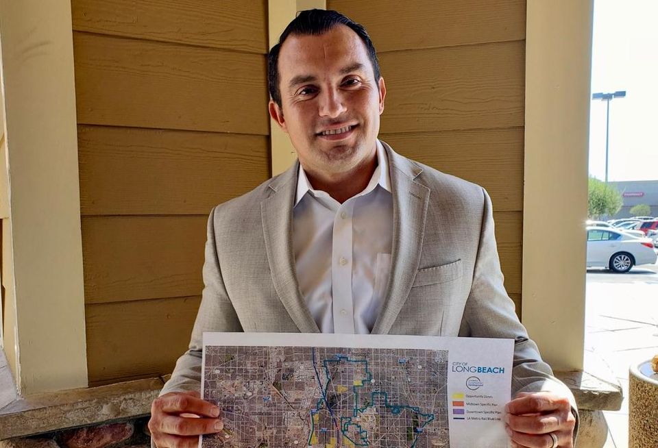 Long Beach Deputy Director of Economic Development Sergio Ramirez holds up a map of the opportunity zones in Long Beach.