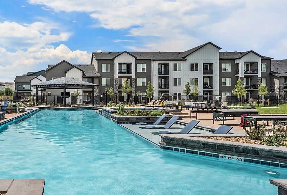 A high-resolution photograph of the Outlook Table Mesa apartments sitting near a swimming pool.