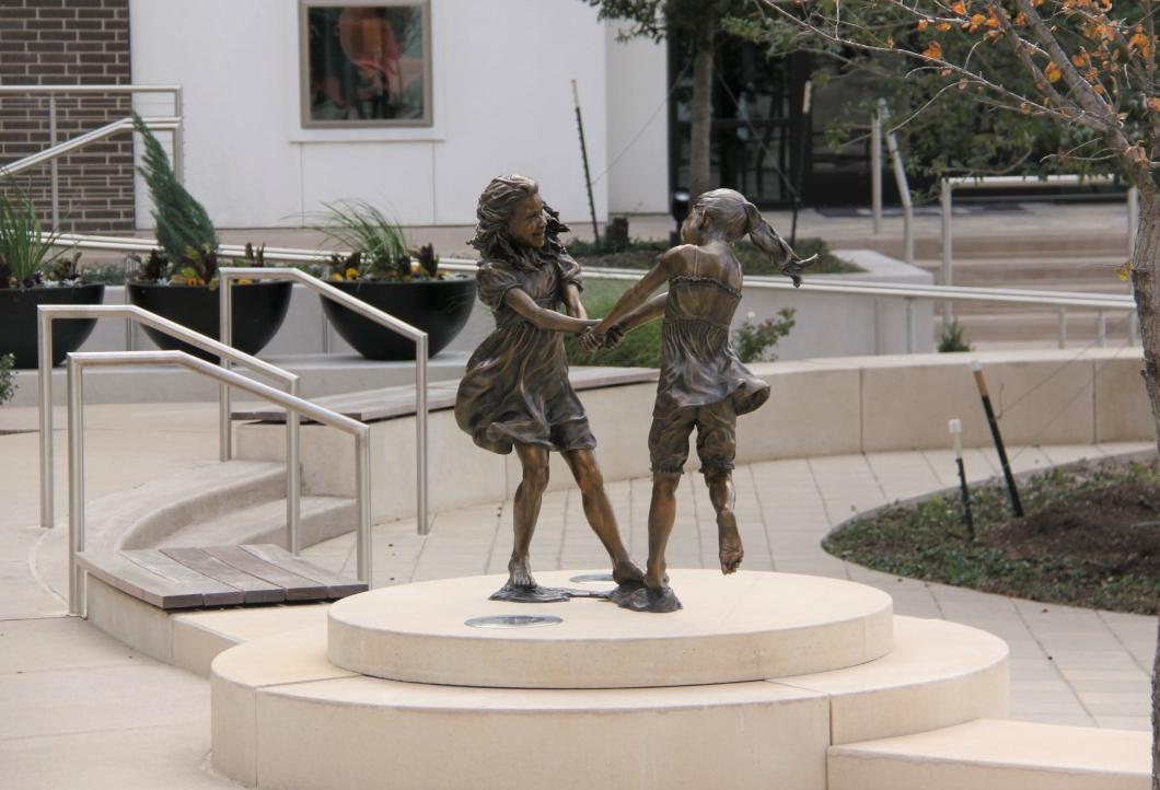 Angela Mia De La Vega’s bronze and clay Whirlwind by Lot A Apartments depicts two young girls dancing. CityLine in Richardson
