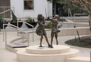 Angela Mia De La Vega’s bronze and clay Whirlwind by Lot A Apartments depicts two young girls dancing. CityLine in Richardson